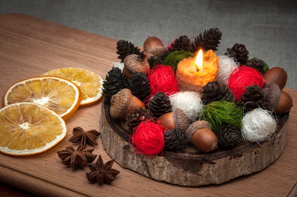 Kerstmis samenstelling - verlichte kaarsenwas, kegels, eikels, ballen, gedroogd oranje, anijs — Stockfoto