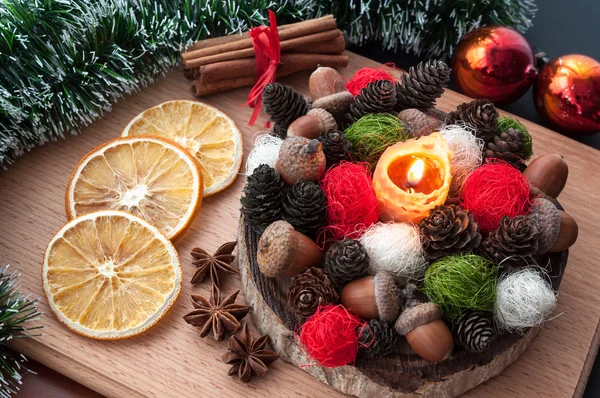 Christmas composition - lit candle wax, cones, acorns, balls, dried orange, anise, cinnamon — Stock Photo, Image