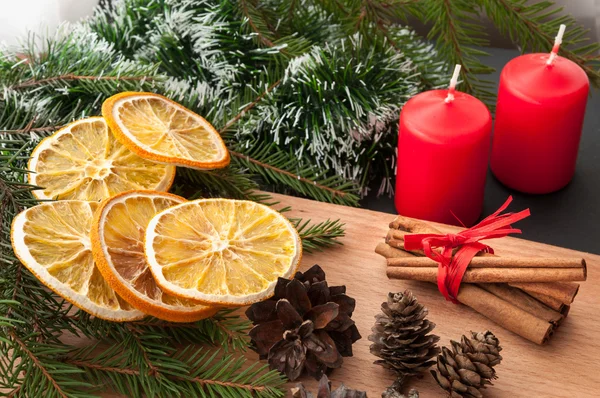 Christmas sammansättning - ljus, kottar, torkad apelsin, kanel, fir trädgren. — Stockfoto