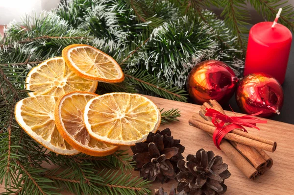 Composición navideña - vela, conos, naranja seca, canela, rama de abeto . —  Fotos de Stock