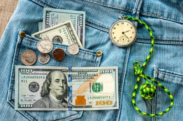 Money, pocket watch on jeans