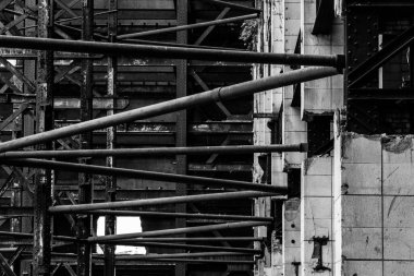 Eski bir duvarı destekleyen borulardan yapılmış metal bir çerçeve.