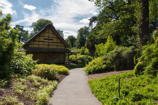 Güneşli bir yaz gününde Kew Gardens 'ta bir kulübe ve Japon bahçeleri.