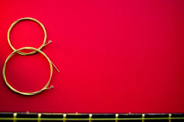 Kırmızı zemin üzerinde sekiz gitar teli figürü.