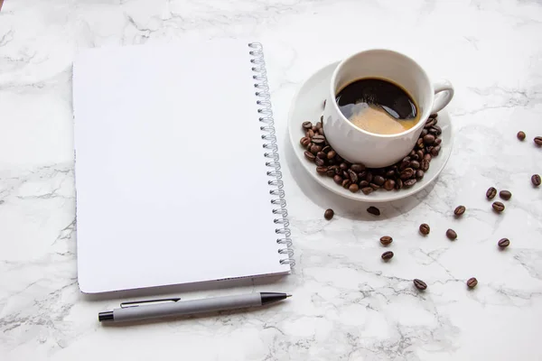 Espresso kahve ve boş sayfalı not defteri. Kalem.