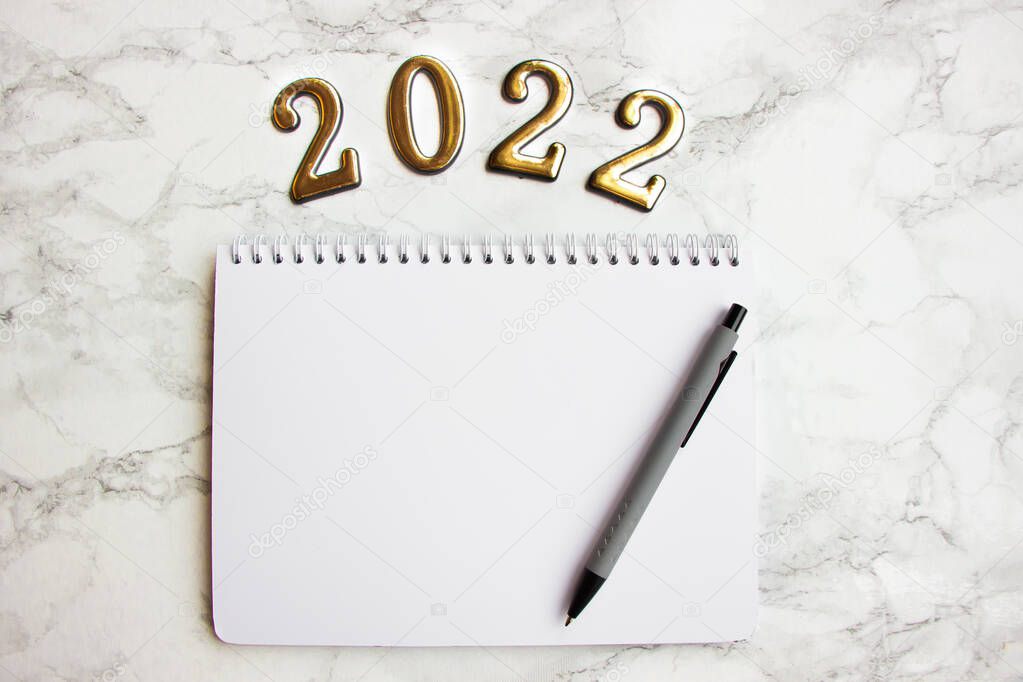 cuaderno con una hoja en blanco, un bolígrafo para escribir planes para