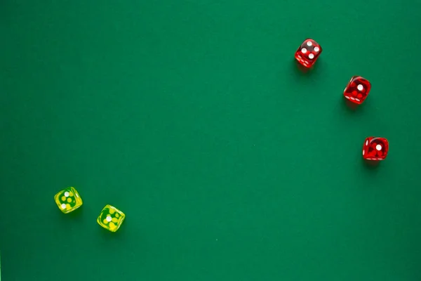 Yeşil arka planda üç kırmızı ve iki sarı zarlar. Boşluğu kopyala