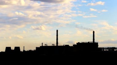 Silhouette sigara bacaları ve bulutlu gökyüzü karşı bina çelik fabrikası