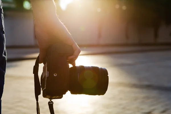 photographer holding a camera in the city with night-lighting