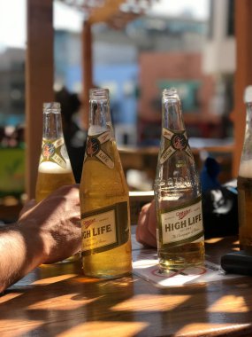 Güneşli bir günde terasta üç HighLife birası.