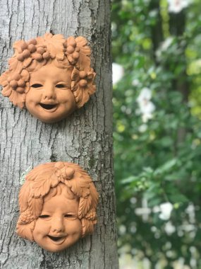 Seramik çocuk ağaçtaki komik yüzler.