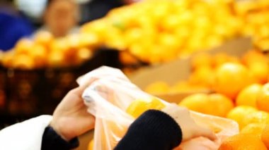 Kız portakal bir süpermarkette seçer.