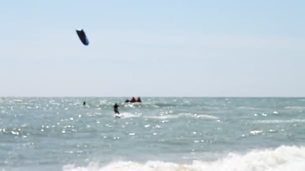 Kitesurfen, een groep van atleten de golven rijden — Stockvideo