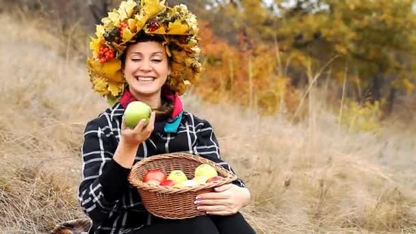 Hermosa joven con una cesta de manzanas maduras — Vídeo de stock