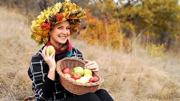 Красива молода дівчина з кошиком стиглих яблук — стокове відео