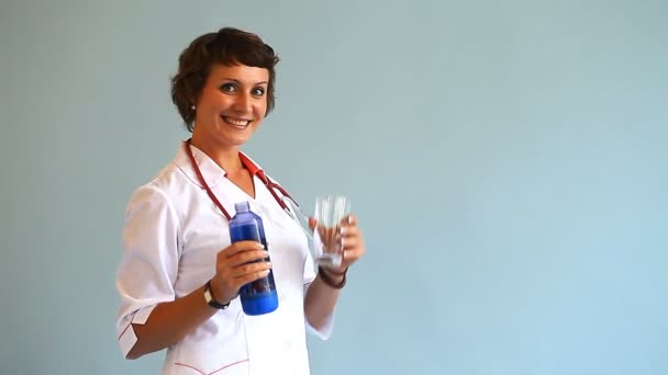 Молода жінка-лікар показує, як корисна вода для здоров'я людини — стокове відео