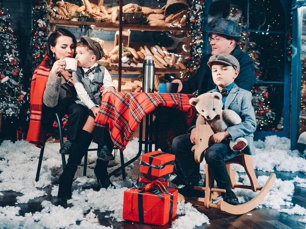 Glad familj klädd i retrostil i vackra nyår dekorationer. Gott nytt år och julafton Familjefirande koncept. Stockfoto
