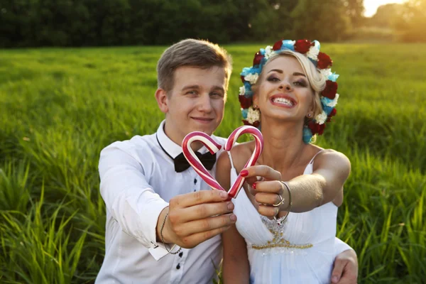 Felice sposa e sposo sul campo verde brillante — Foto Stock