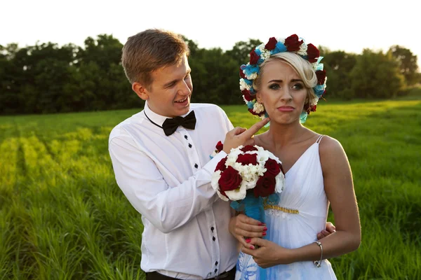 Felice sposa e sposo sul campo verde brillante — Foto Stock