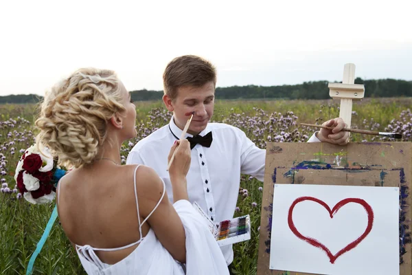 Nevěsta a ženich malovat na stojan emoce — Stock fotografie