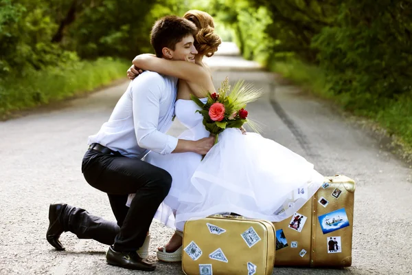Gyönyörű menyasszony és a vőlegény, a közúti auto-stop — Stock Fotó