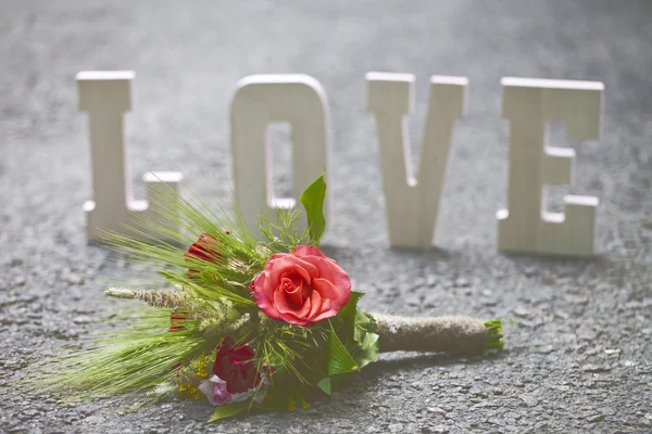 The word love and a bouquet of flowers — Stock Photo, Image