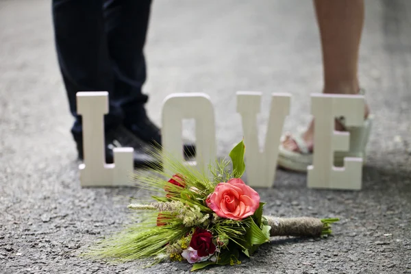 La palabra amor y un ramo de flores — Foto de Stock