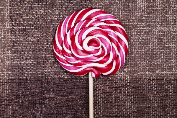 Röd lollipop sockerkulör brun bakgrund — Stockfoto
