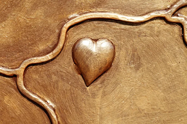 Beautiful heart of metal painted in gold paint — Stock Photo, Image