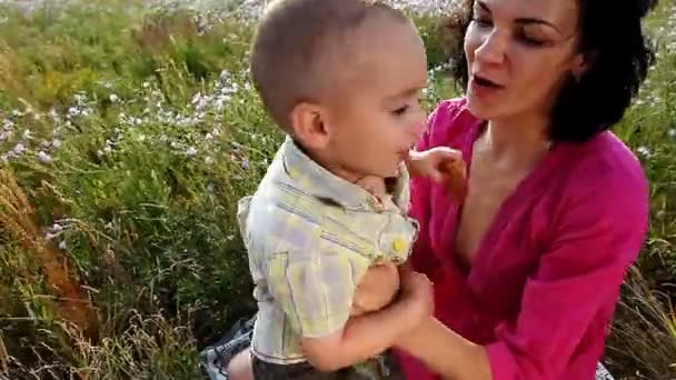 Счастливые мать и сын играют на свежем воздухе — стоковое видео