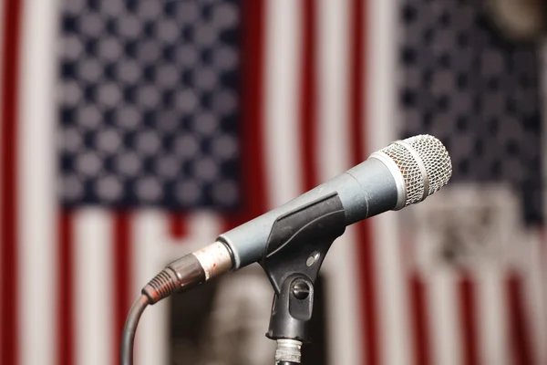Old vintage microphone on the background of the American flag — Stock Photo, Image