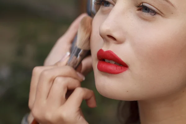 Maquillaje maestro pintar un hermoso joven primer plano —  Fotos de Stock