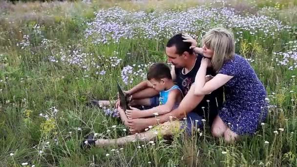 Família feliz na natureza com computador — Vídeo de Stock