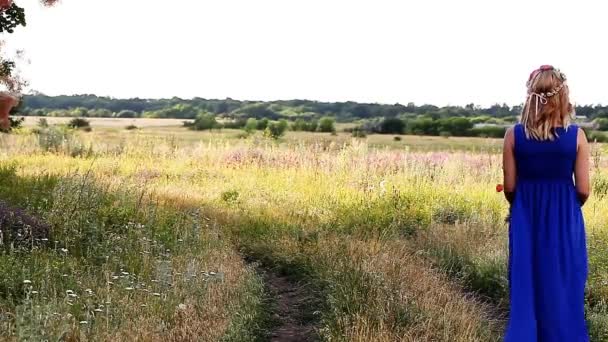 Romantische meisje lopen op de weg in een blauwe jurk — Stockvideo