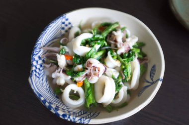 Kızarmış fesleğen, kalamarla birlikte beyaz bir kasede çıkar.