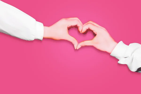 Hände in Herzform isoliert auf rosa Hintergrund, Arme tragen lange weiße Ärmel — Stockfoto