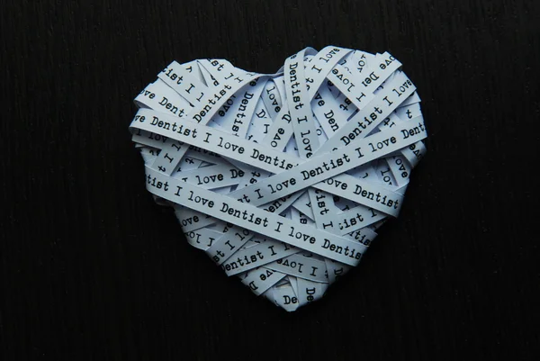 White paper ribbon in heart shape showed text 'I love dentist' on dark background — Stock Photo, Image