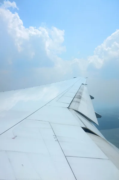 Ala de avião voando acima das nuvens com céu agradável — Fotografia de Stock