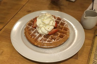 Krem şanti, çilek ve krema ile waffle