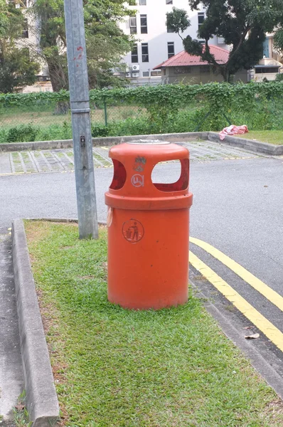 Оранжевый пластиковый мусорный бак в общественном месте — стоковое фото