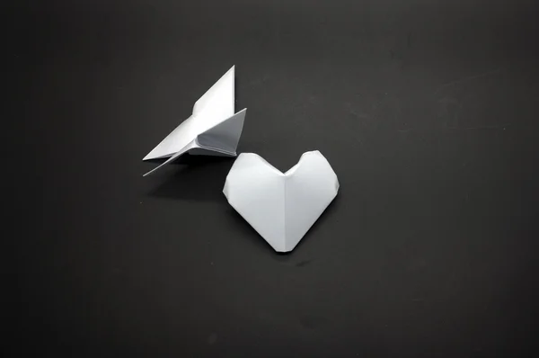 Weißer Origami-Schmetterling und herzförmiges Papier — Stockfoto