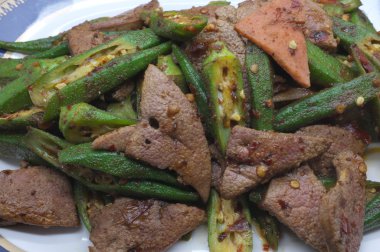 Kızarmış domuz karaciğer bamya, kadının parmak ile karıştırın