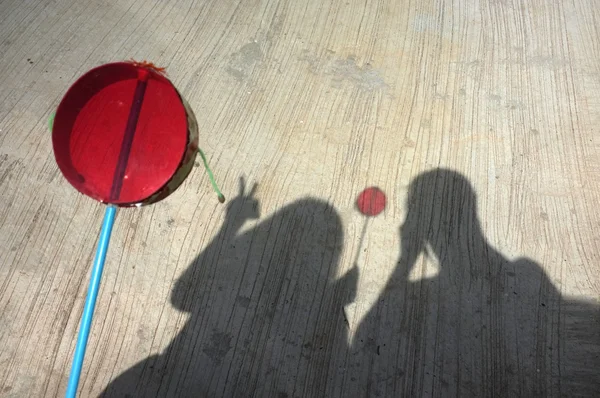 Silhueta de casal jogar ásia mão tambor brinquedo — Fotografia de Stock