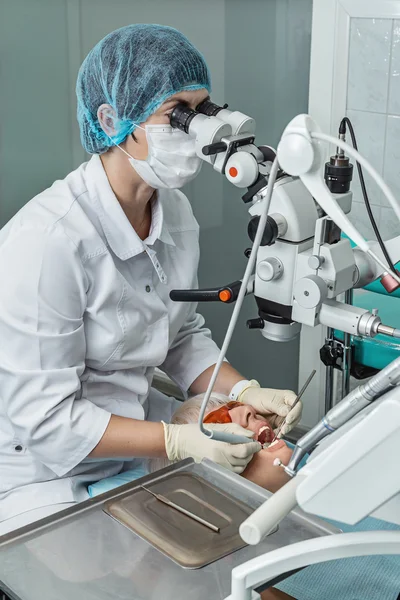 Dentista che guarda attraverso un microscopio . — Foto Stock