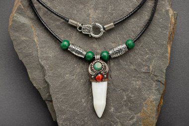 Timsah dişli gümüş kolye ve taştan arka planda turkuaz. Yakın çekim, stüdyo çekimi..