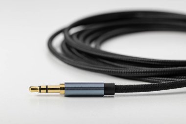 Elektronikleri bağlamak için fişi olan siyah esnek ses kablosu.