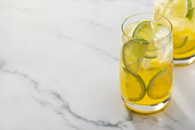 Limonlu ve limonlu iki bardak ferahlatıcı limonata. Boşluğu kopyala, mermer arkaplan.