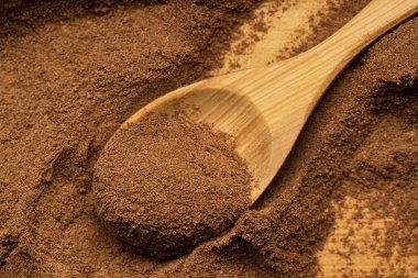 Tahta bir yüzeye tarçın ve tarçın tozu sürülmüş ahşap kaşık. Baharatlar ve baharatlar.