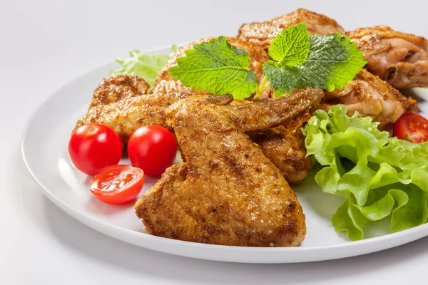 Chicken wings with lettuce, tomatoes and mint — Stock Photo, Image