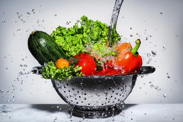 Groenten in een vergiet onder stromend water — Stockfoto